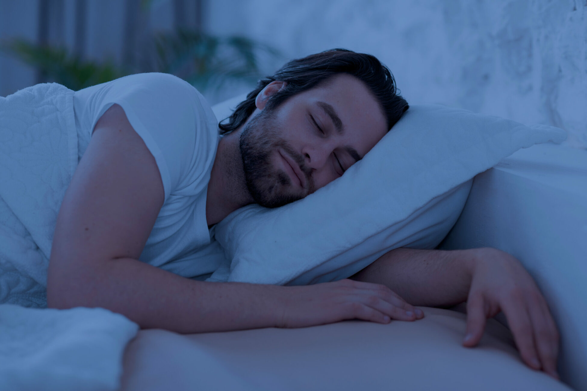 Man sleeping in deep sleep state on white bed